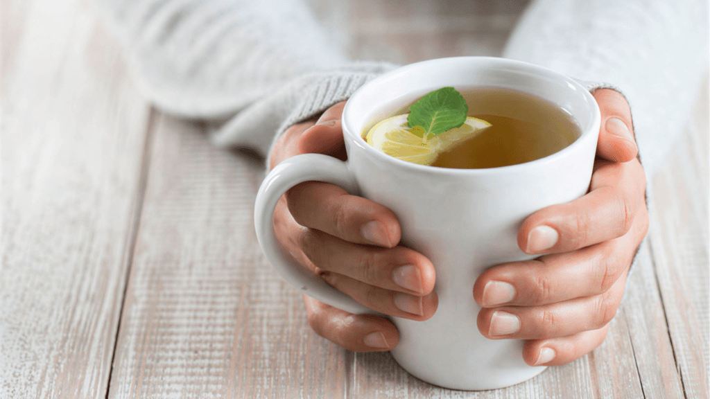Frau entspannt mit einer warmen Tasse Tee gegen Bauchschmerzen und Blähungen